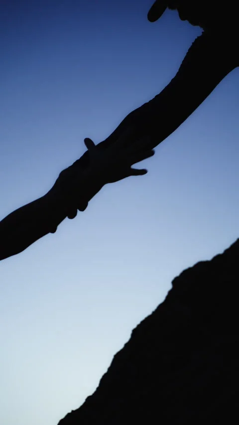 Dramatic silhouette of helping hand pulling another climber up steep mounta.. Stock Footage 339911342