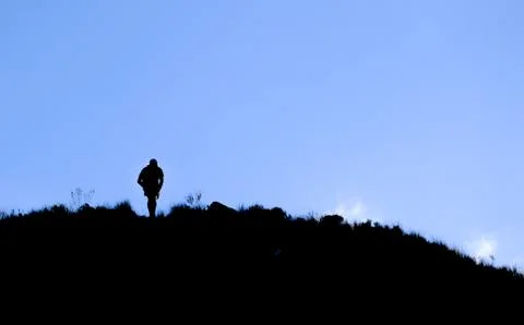 Dramatic silhouette of a trail runner high up on on a mountain Stock Photos