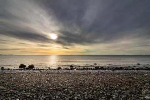 Dramatic sky and ocean view from the pebble shore in the island of Jomfruland in Stock Photos