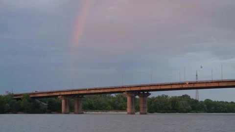 Dramatic sky and rainbow. Road bridge across the river. Rainbow over the river Stock Footage 217823481