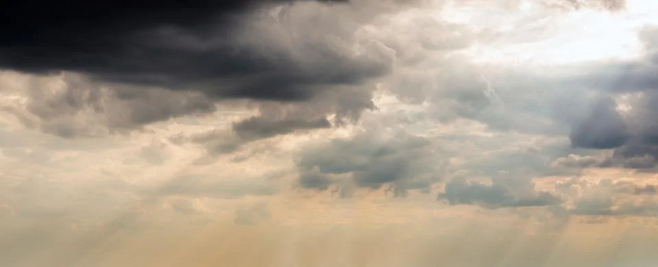 Dramatic Sky Background with sunny beams. Panoramic view of Stormy Clouds in Stock Photos