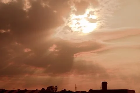 Dramatic sky between clouds in the late afternoon and the silhouette of a fa Foto stock