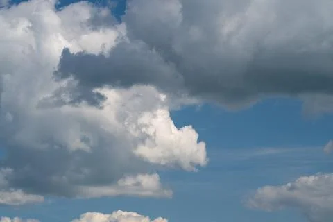 Dramatic sky with billowing cumulus clouds over blue horizon Stock Photos