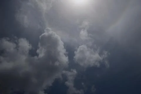 Dramatic sky bright sun behind cloud in blue sky Stock Photos