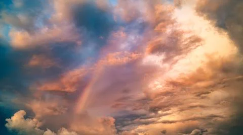 Dramatic sky with cloud and rainbow in the sunset Stock Photos