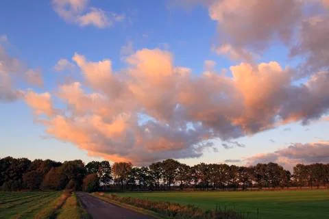 Dramatic sky with clouds illuminated in red light from the late evening sun a Stock Photos