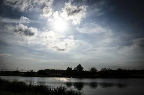 Dramatic sky with clouds over the river. Nature composition. Stock Photos