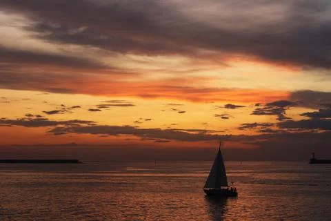 Dramatic sky with colorful clouds, calm sea and floating boat Stock Photos