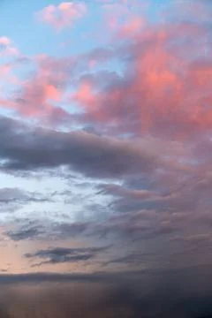 Dramatic sky with dark and pink-tinted clouds, perfect for impactful visuals Stock Photos