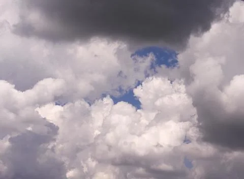 Dramatic sky with dark and white clouds, patches of blue visible, Stock Photos