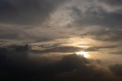 Dramatic sky with dark clouds and golden sunbeam piercing through Stock Photos
