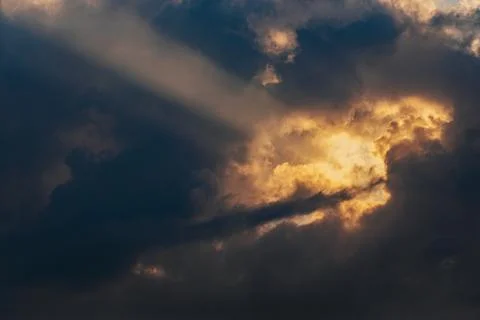 Dramatic sky with dark clouds and rays of sunlight breaking through, creati.. Stock Photos