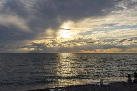 Dramatic sky with dark clouds on calm sea at sunset. Black Sea coast, early a Stock Photos
