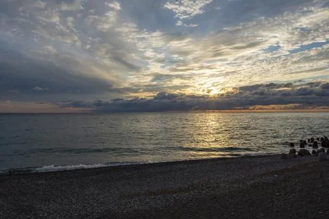 Dramatic sky with dark clouds on calm sea at sunset. Black Sea coast, early.. Stock Photos