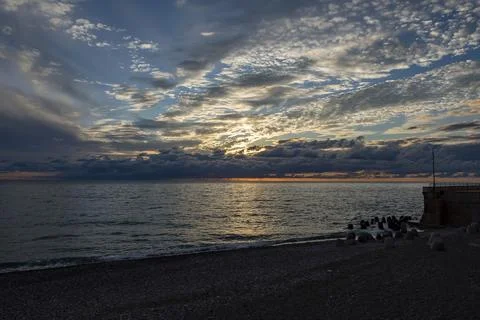 Dramatic sky with dark clouds on calm sea at sunset. Black Sea coast, early.. Stock Photos