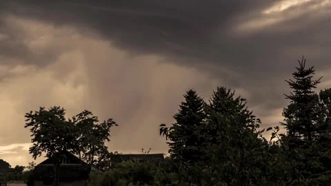 Dramatic Sky with Dark Storm Clouds Over Landscape and Roofline Stockbeeldmateriaal 313053093