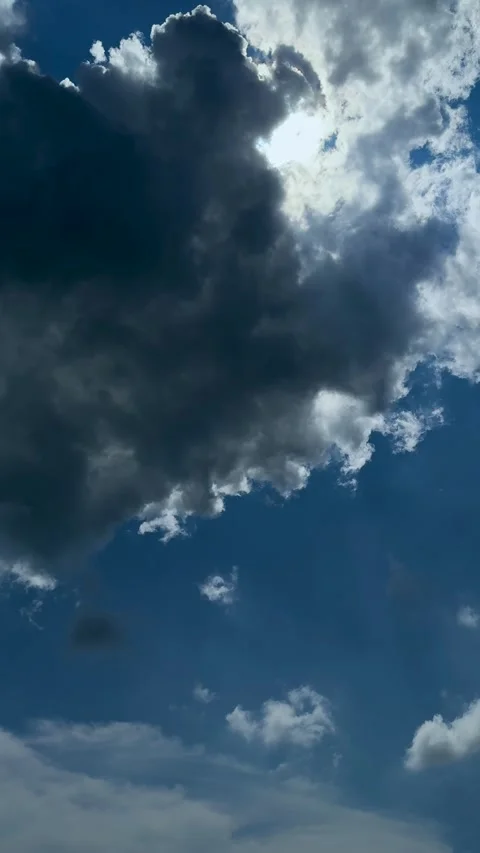Dramatic sky with dark storm clouds contrasting against a vibrant blue sky .. Stock Footage 338414377