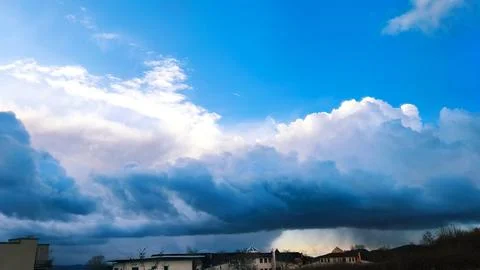 Dramatic sky with dark storm clouds and a bright blue sky above the horizon Stock Photos