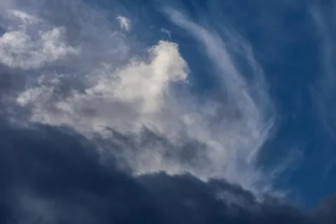 Dramatic sky with dark storm clouds and wispy cirrus formations Stock Photos