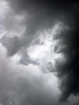 Dramatic sky with dark storm clouds and bright light breaking through Stock Photos