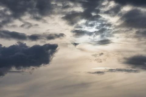 Dramatic sky with dark storm clouds and bright sunlight breaking through Stock Photos