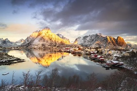 Dramatic sky at dawn over Mount Olstind covered with snow, Reine Bay, Nordland, Stock Photos