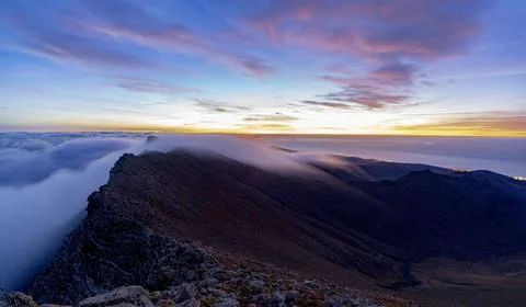 Dramatic sky at dawn over Pico de la Zarza mountain peak in mist, Jandia Stock Photos