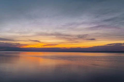 Dramatic sky during colorful red and purple sunset over the ocean on the outer Stock Photos