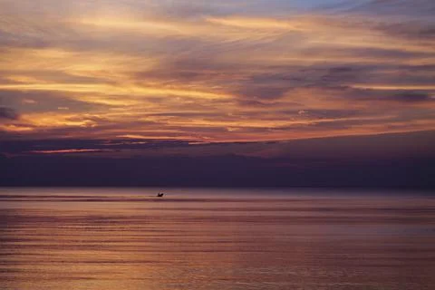 Dramatic sky during colorful red and purple sunset over the ocean on the outer Stock Photos