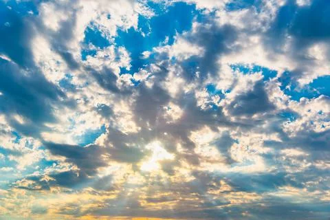 Dramatic sky with feather clouds. Sun's rays shine through clouds. Stock Photos