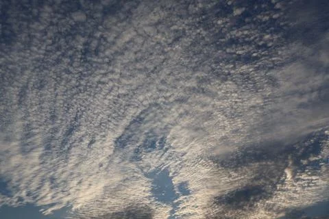 Dramatic sky filled with altocumulus clouds on a bright, sunny day Stock Photos