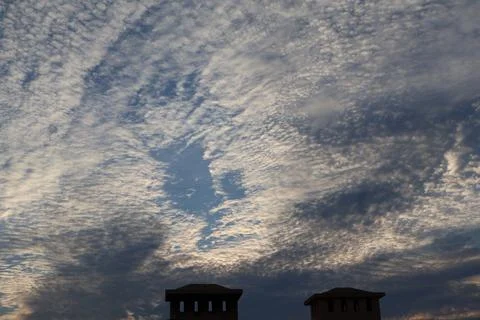 Dramatic sky filled with altocumulus clouds and a glimpse of blue Stock Photos