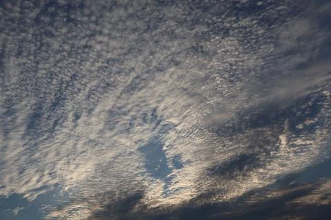 Dramatic sky filled with altocumulus clouds on a sunny day Stock Photos
