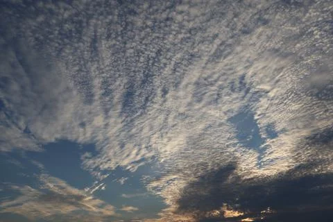 Dramatic sky filled with altocumulus clouds at sunset or sunrise Stock Photos