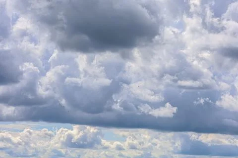 Dramatic sky filled with dark and light cumulus clouds on a bright day 库存照片