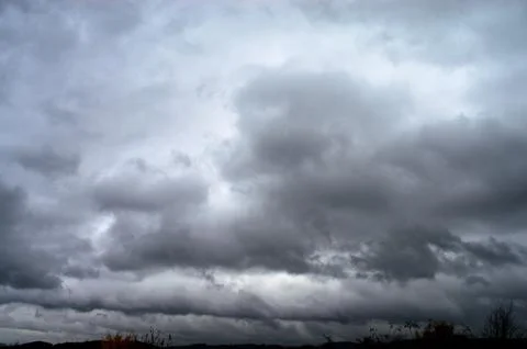 Dramatic sky filled with dark, ominous storm clouds before a downpour Stock Photos