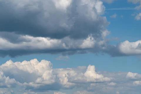 Dramatic sky filled with layered cumulus clouds over blue horizon Stock Photos