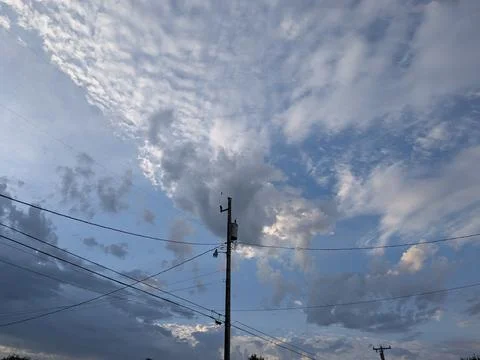 A dramatic sky filled with shades of blue, gray, white, and black Stock Photos