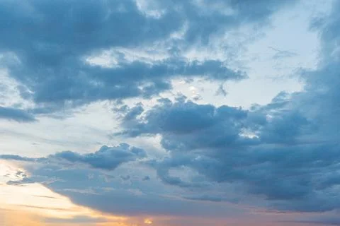 A dramatic sky filled with thick yet translucent clouds, depicted in warm h.. Stock Photos