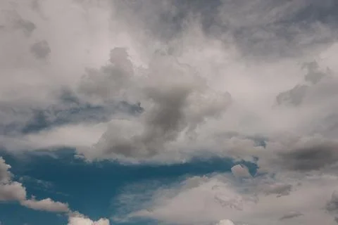 Dramatic Sky with Fluffy White and Dark Grey Clouds Moving Across Vibrant B.. 写真素材