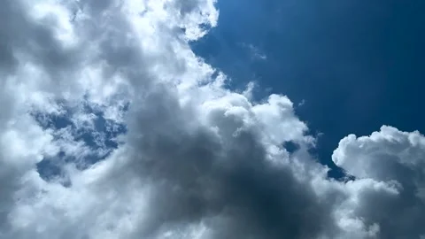 Dramatic sky with fluffy white clouds against a vibrant blue background on .. Stock Footage 339295851