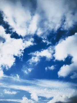 Dramatic sky with fluffy white clouds against deep blue expanse 写真素材