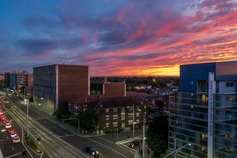 Dramatic sky with intense sunset colors over suburban buildings Stock Photos