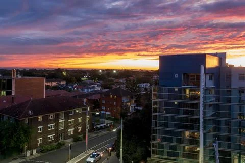 Dramatic sky with intense sunset colors over suburban buildings Stock-Fotos