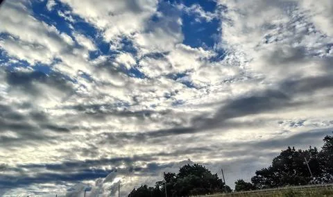 Dramatic sky with layered clouds and patches of blue on a bright day Stock Photos