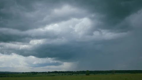 A dramatic sky looms over a beautiful green landscape, capturing natures unique Stock Footage 312273175