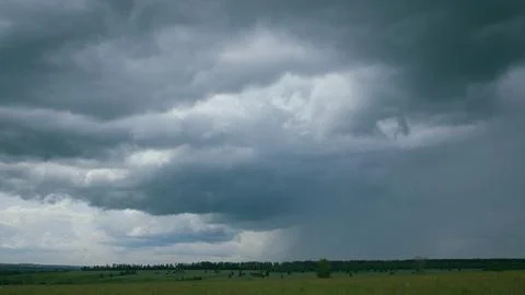 A dramatic sky looms over a beautiful green landscape, capturing natures unique Stock Photos