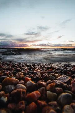Dramatic sky with a mix of red, orange and purple over the waves of Lake Oulu Stock Photos