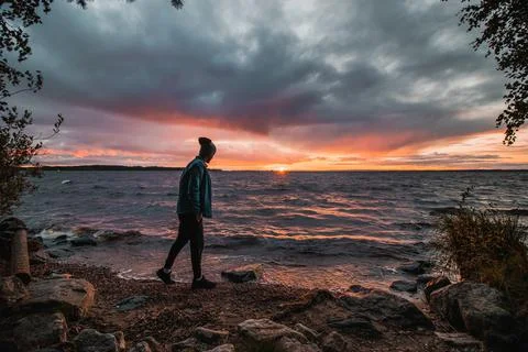Dramatic sky with a mix of red, orange and purple over the waves of Lake Oulu Foto stock
