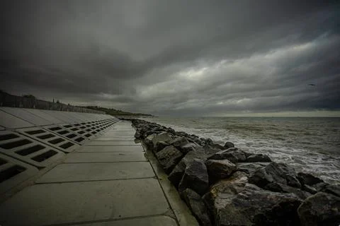 Dramatic sky over the black sea with waves, clouds and stones Stock Photos